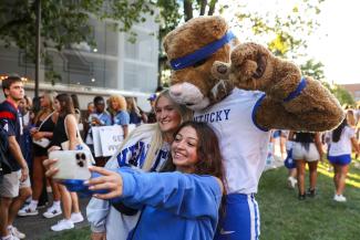 Photo of two students taking a selfie with the Wildcat mascot