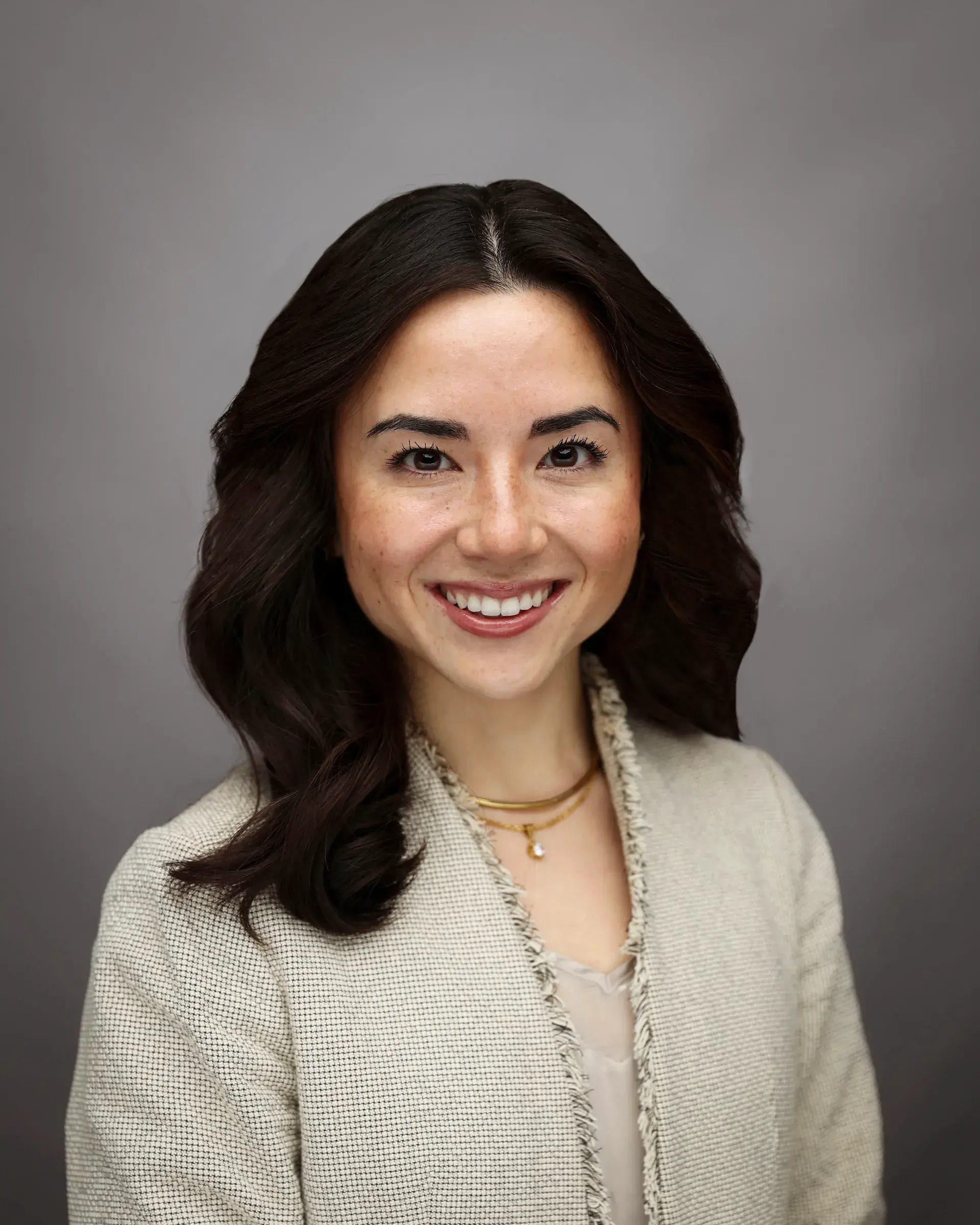 headshot of woman against gray backdrop 
